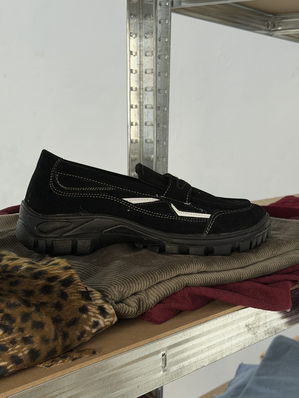 Sepatu loafer hitam di atas meja jahit workshop produksi sepatu Sidoarjo